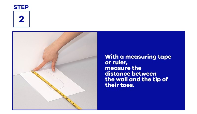 hand holding measuring tape on A4 paper with instructions on measuring feet