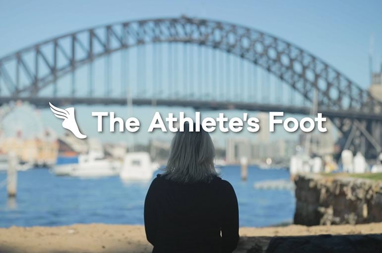 back of women, staring at Sydney Harbour with TAF logo