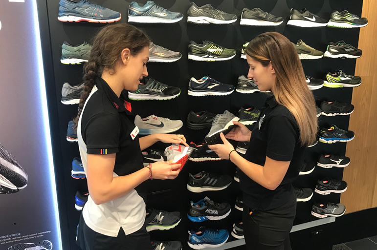 two TAF employees holding shoes>
<p class=